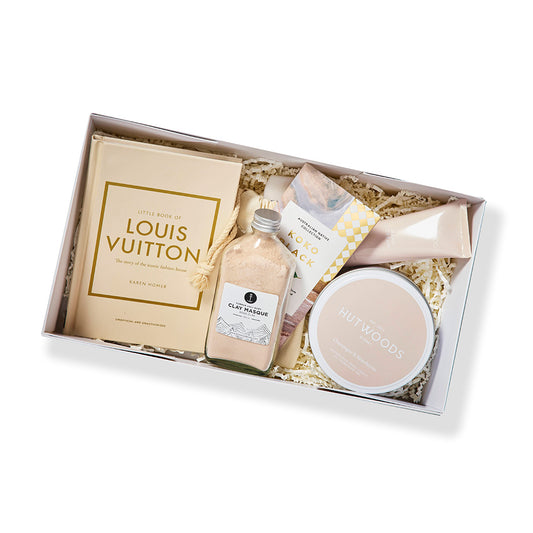 Pamper hamper gift set with mini book, rose clay face masque, body care essentials, and gourmet chocolate for self-care.