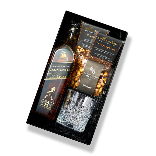 Whiskey gift hamper with Johnnie Walker Black, crystal tumbler, premium chocolate blocks, and nuts from Gift Republiq.